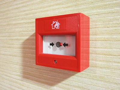 Red manual fire alarm call point on a wall